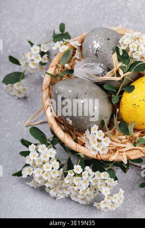 Easter eggs in wicker basket with blossom flowers Stock Photo