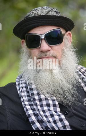 Portrait of mature bearded hipster man at the park outdoors Stock Photo