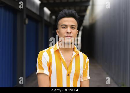 Portrait of young handsome multi ethnic man outside of the building Stock Photo