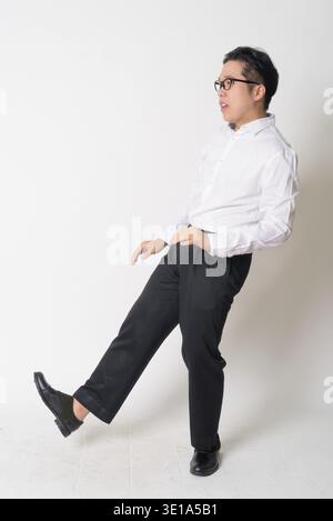 Studio shot of young Asian businessman with eyeglasses against white background Stock Photo