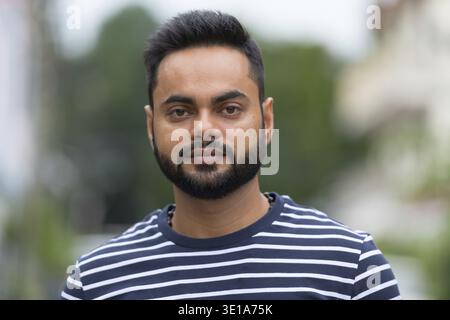 Portrait of young bearded Indian man in the streets outdoors Stock Photo