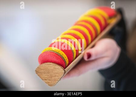 Close-up of colorful macarons arranged in on a ceramic tray with yellow, green, and red colors inspired by the Lithuanian flag Stock Photo