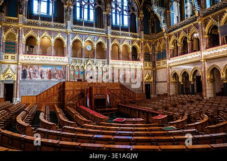 Interior view of the main debating chamber showing tiered wooden seating, Gothic Revival architecture, and historical murals, Hungarian Parliament Bui Stock Photo