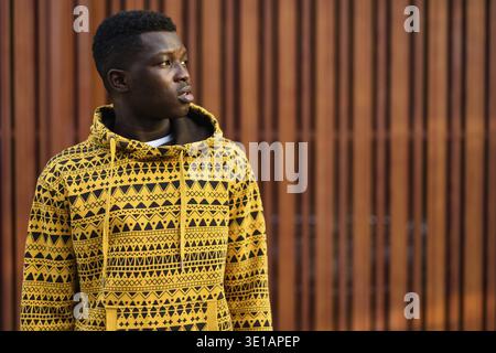 Young black African man thinking against wooden gate Stock Photo