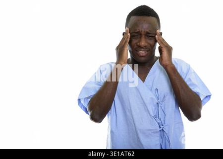 Studio shot of young stressed black African man patient having headache Stock Photo