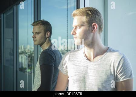 Portrait of young handsome man with blond hair in the city outdoors Stock Photo