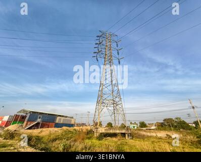 large metal transmission tower, electricity pylon, positioned in a field under a blue sky, Phnom Penh SEZ (PPSEZ), Cambodia, Asia Stock Photo