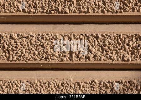 Rough texture wall with horizontal plaster bands creating a detailed pattern Stock Photo