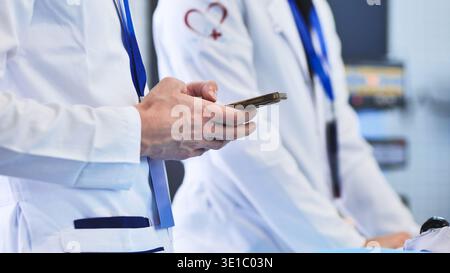 Medical professional using smartphone, connecting in a healthcare environment Stock Photo