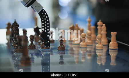Robot arm moving chess piece on board, depicting artificial intelligence and strategy Stock Photo