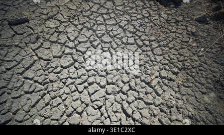 Dry cracked soil creating a textured surface in crimea, highlighting the effects of drought and arid conditions Stock Photo