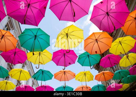 Multicolored umbrellas against a blue sky Stock Photo