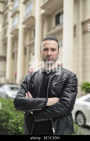 Confident bearded man wearing black leather jacket Stock Photo
