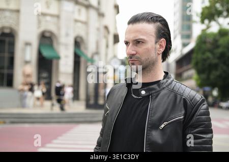 Confident bearded man wearing black leather jacket Stock Photo