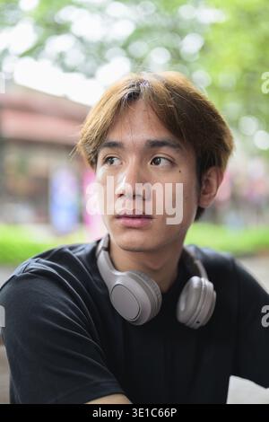 Portrait of a young Thai Asian man in casual style posing for modern lifestyle photography. Confident, relaxed, and authentic look suitable for variou Stock Photo