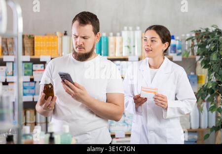 Man buyer scans syrup qr code with woman pharmacist Stock Photo