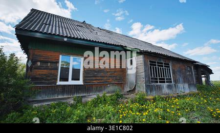 Old abandoned wooden house falling apart in slavic village Stock Photo