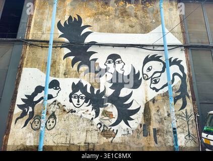 striking mural painting on an old, textured wall, featuring stylized black and white figures and abstract shapes. Phnom Penh, Cambodia Stock Photo
