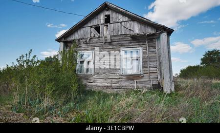 Old abandoned wooden house falling apart in slavic village Stock Photo