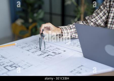 Architectural Drawing of Building Project with Colleagues Designing Blueprint Using Compasses Stock Photo
