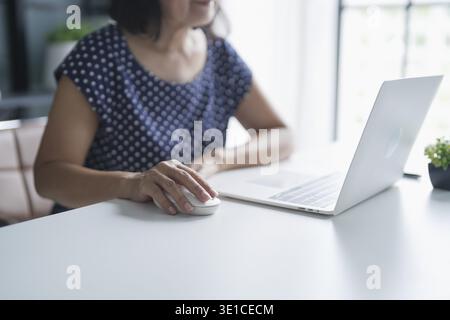 Mature Asian woman Work from home. senior asian woman on laptop with technology concept Stock Photo