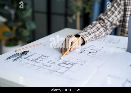 Architectural Drawing of Building Project with Colleagues Designing Blueprint Using Compasses Stock Photo