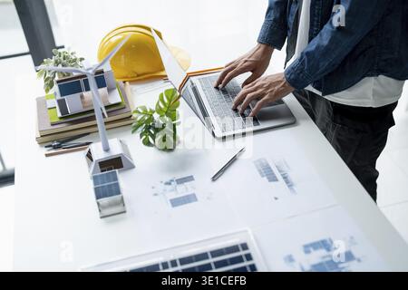 Businessman and Engineers Working on Solar Panels Project for Green Energy Accumulation in Eco-Friendly Office Stock Photo
