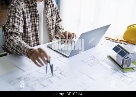 Architectural Drawing of Building Project with Colleagues Designing Blueprint Using Compasses Stock Photo