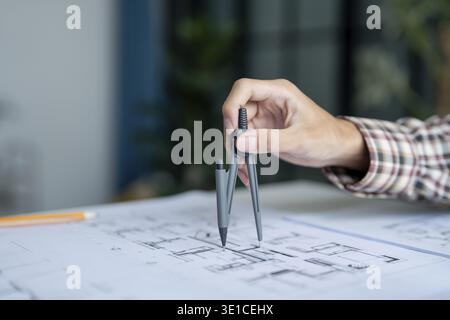 Architectural Drawing of Building Project with Colleagues Designing Blueprint Using Compasses Stock Photo