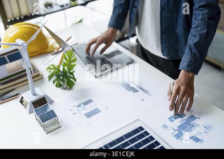 Businessman and Engineers Working on Solar Panels Project for Green Energy Accumulation in Eco-Friendly Office Stock Photo