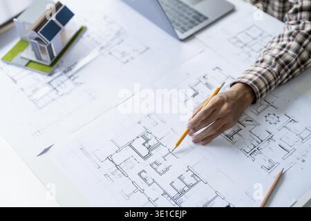 Architectural Drawing of Building Project with Colleagues Designing Blueprint Using Compasses Stock Photo