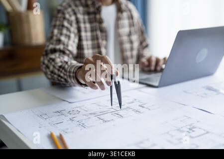 Architectural Drawing of Building Project with Colleagues Designing Blueprint Using Compasses Stock Photo