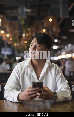 Portrait of Handsome Young Asian Man Sitting in Coffee Shop Restaurant Concept Stock Photo