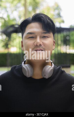 Portrait of Handsome Young Asian Man Outdoors in Park Concept Stock Photo