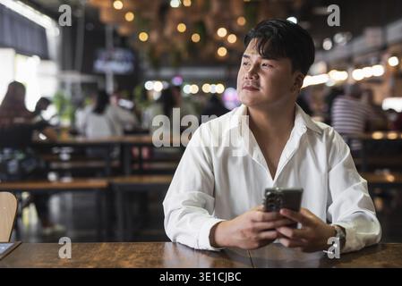 Portrait of Handsome Young Asian Man Sitting in Coffee Shop Restaurant Concept Stock Photo