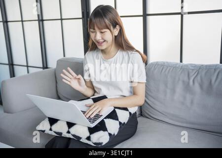 Asian woman video call with family by using laptop Stock Photo