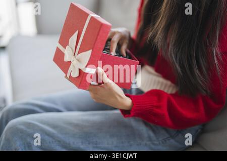 Receiving Valentine present. Cheerful girl asian holding gift box Stock Photo