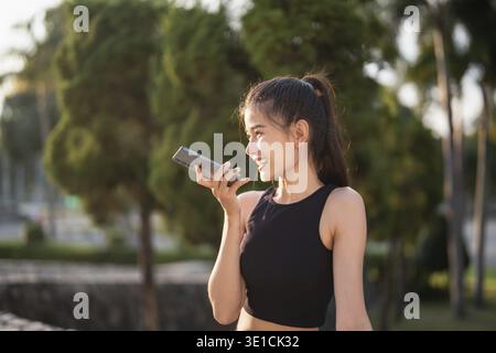 Asian woman using voice assistant on smartphone conversation with online assistant Voice chat bot conversational AI Modern Technologies Stock Photo