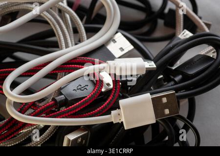 Various USB cables and connectors tangled together showing everyday technology accessories and device connections. Stock Photo