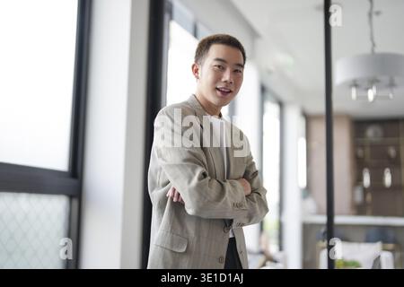 Smiling young Asian businessman in modern office. handsome asian man happy and friendly while working success job Stock Photo