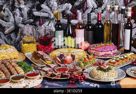 Opulent holiday table laden with a variety of gourmet dishes and fine wines amidst christmas decor Stock Photo