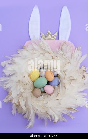 Easter scene with colored eggs in nest with rabbit ears Stock Photo
