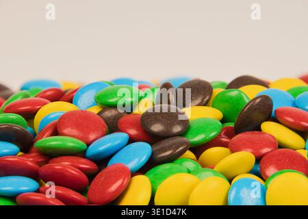 Assortment of colorful candy coated chocolate buttons scattered, filling the frame with sweetness Stock Photo