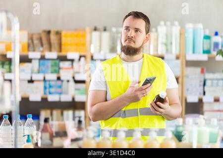 Male builder scans code on cough syrup to check expiration date Stock Photo