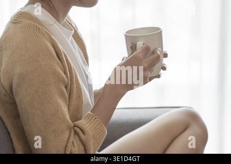 Asian Woman hands holding cup of coffee Stock Photo