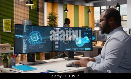 Engineer working on wind turbine simulation in office using artificial intelligence. RD department worker using AI tech and CAD program, doing renewable energy generation engineering, camera A Stock Photo