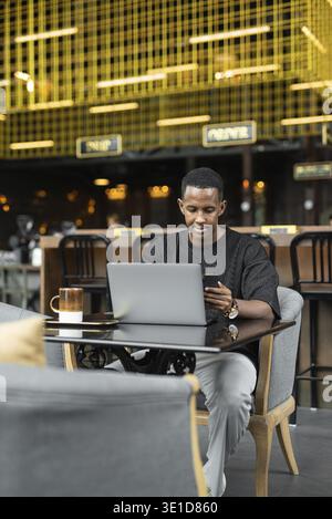 Portrait of handsome young black man using laptop computer in coffee shop Stock Photo