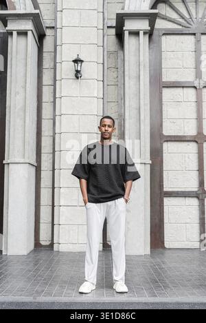 Full body portrait of handsome young African man standing outdoors Stock Photo