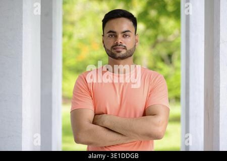 Portrait of young handsome bearded Indian man at the park outdoors Stock Photo