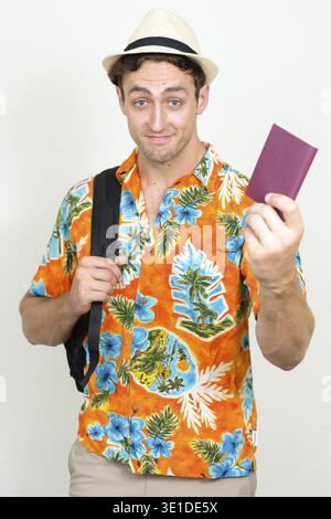 Studio shot of young handsome tourist man ready for vacation against white background Stock Photo